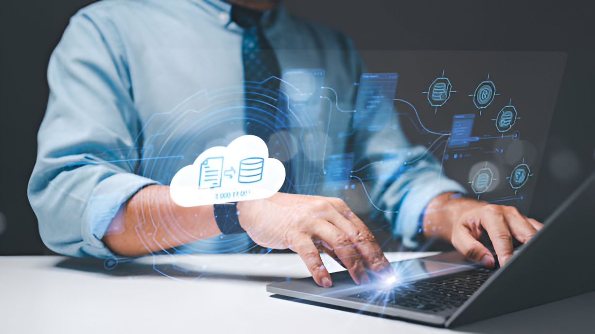 professionally dressed man typing on a laptop with holographic code overlays