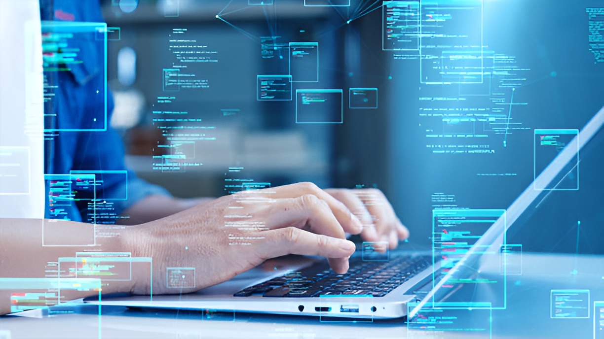 person typing on a laptop with holographic codes